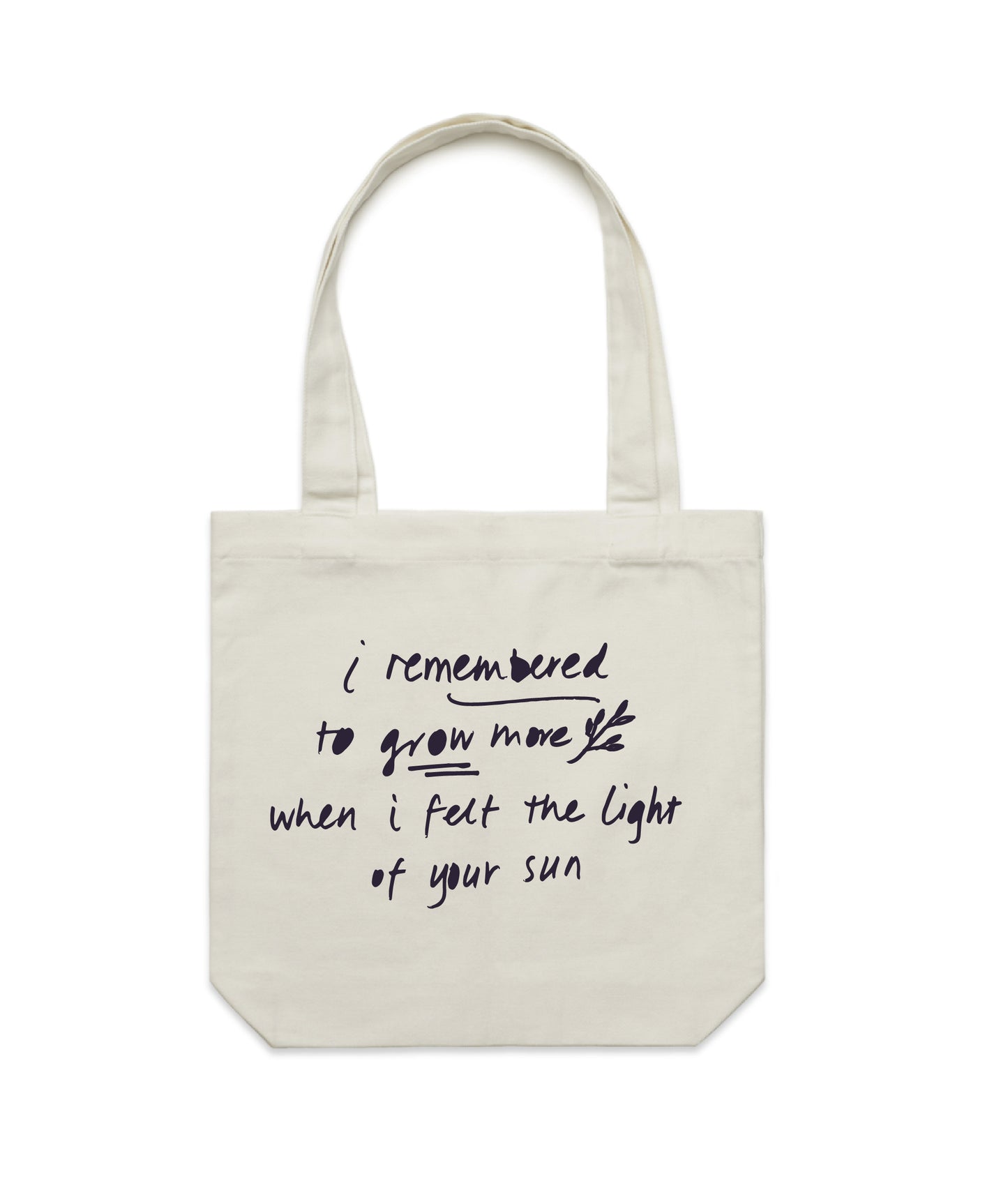 Kav Temperley tote Flat lay of cream tote bag reading 'I remembered to grow more when I felt the light of your sun' in ink navy